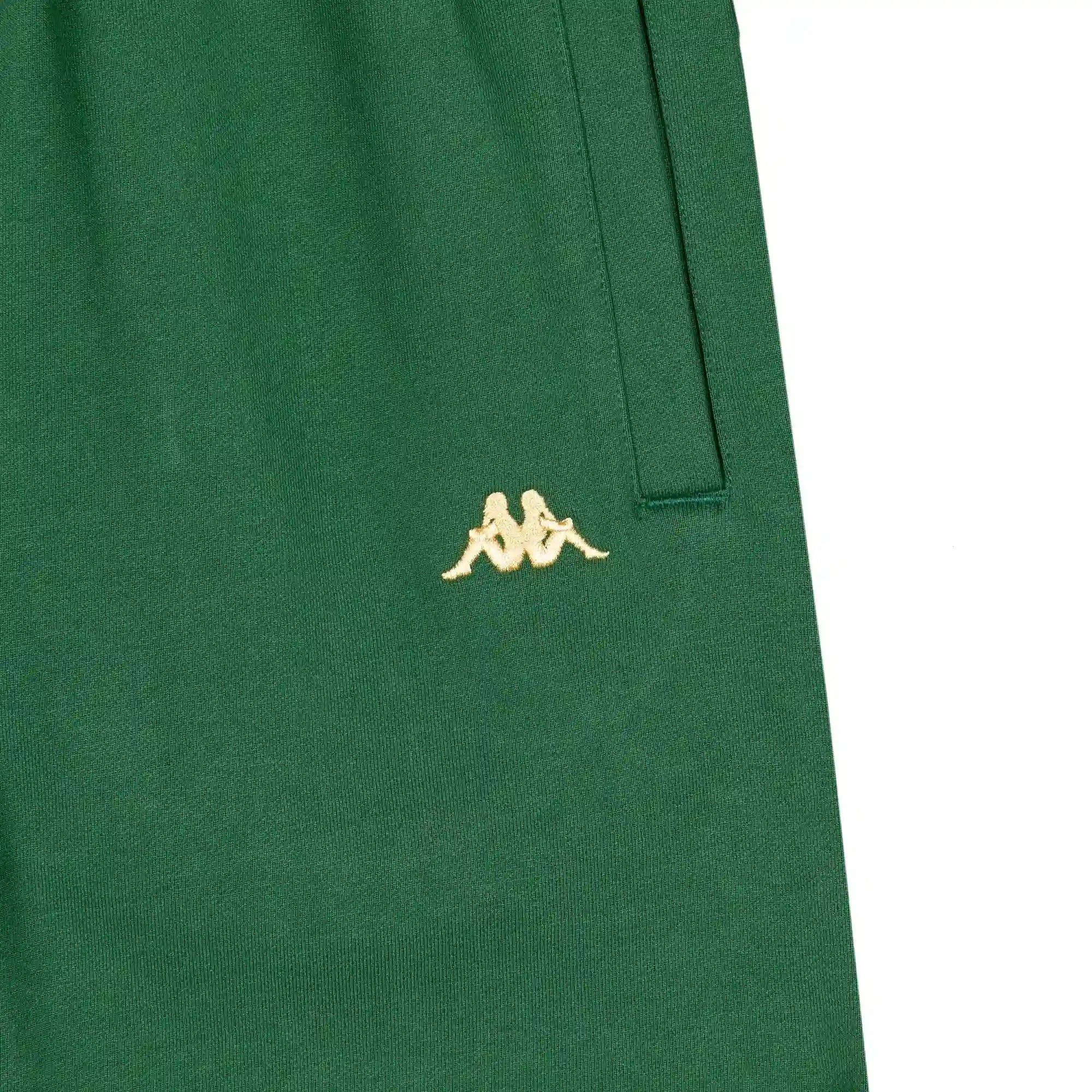 Detail view of golden yellow embroidered Kappa Omini logo on green shorts.