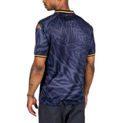 Male model wearing Kombat 2025 Modelo Soccer Jersey in navy blue and gold. Back view.