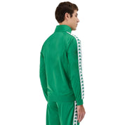 Man wearing green Kappa track jacket with white and green banda going down the arms and Omini logo in white on left side. Back view.