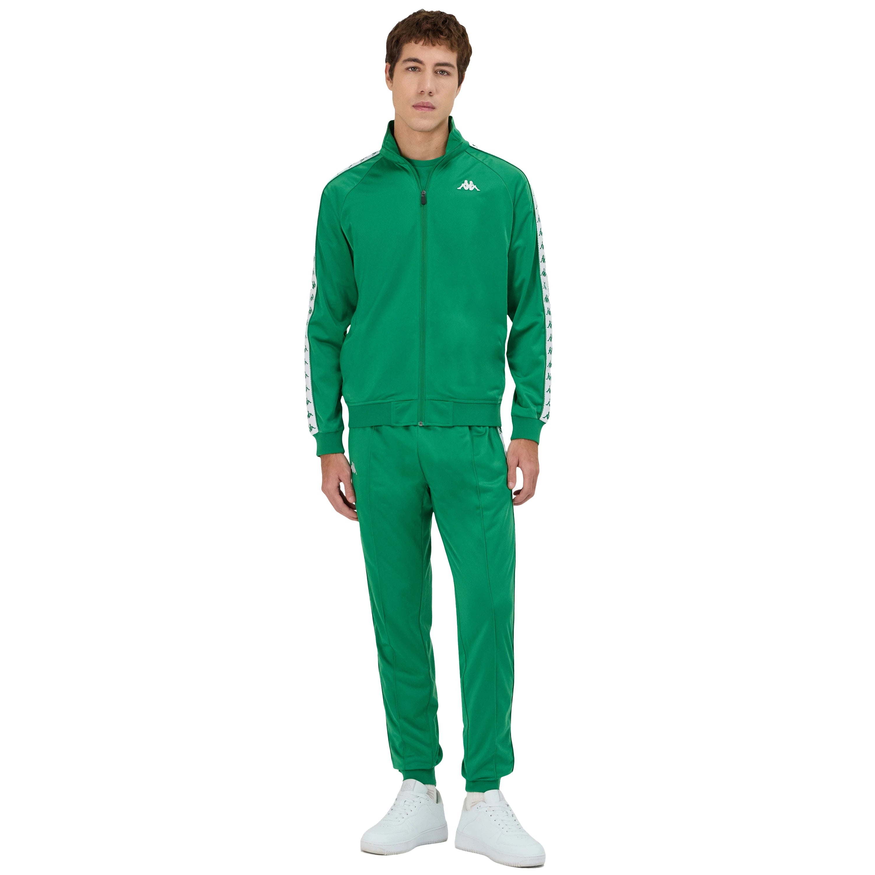 Man wearing Green Kappa track pants featuring Kappa Banda on side of legs in white and green. White Omini logo on right leg. Full body view with matching track jacket.