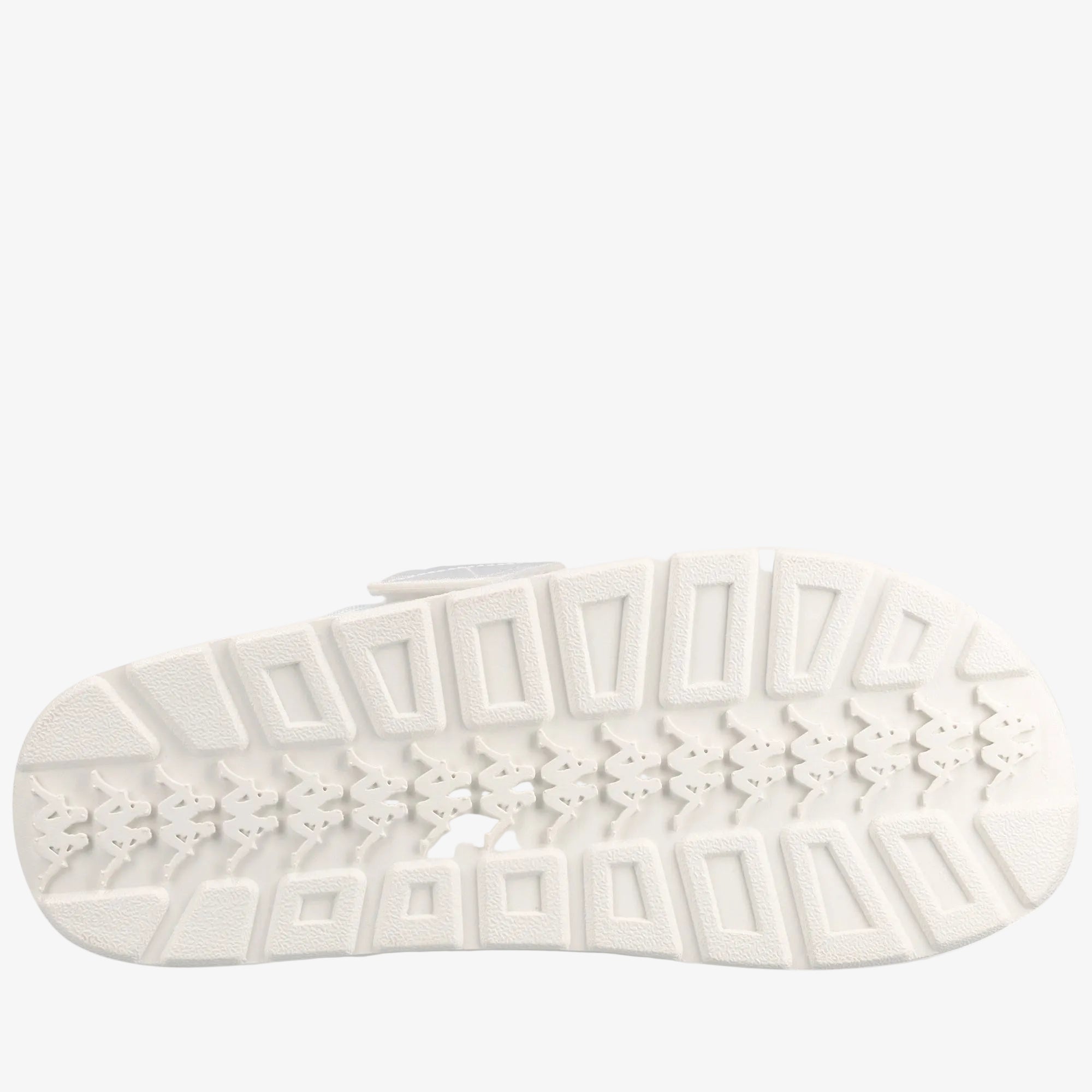 A close-up, top-down view of a white textured shoe sole with geometric tread patterns, set against a solid white background.