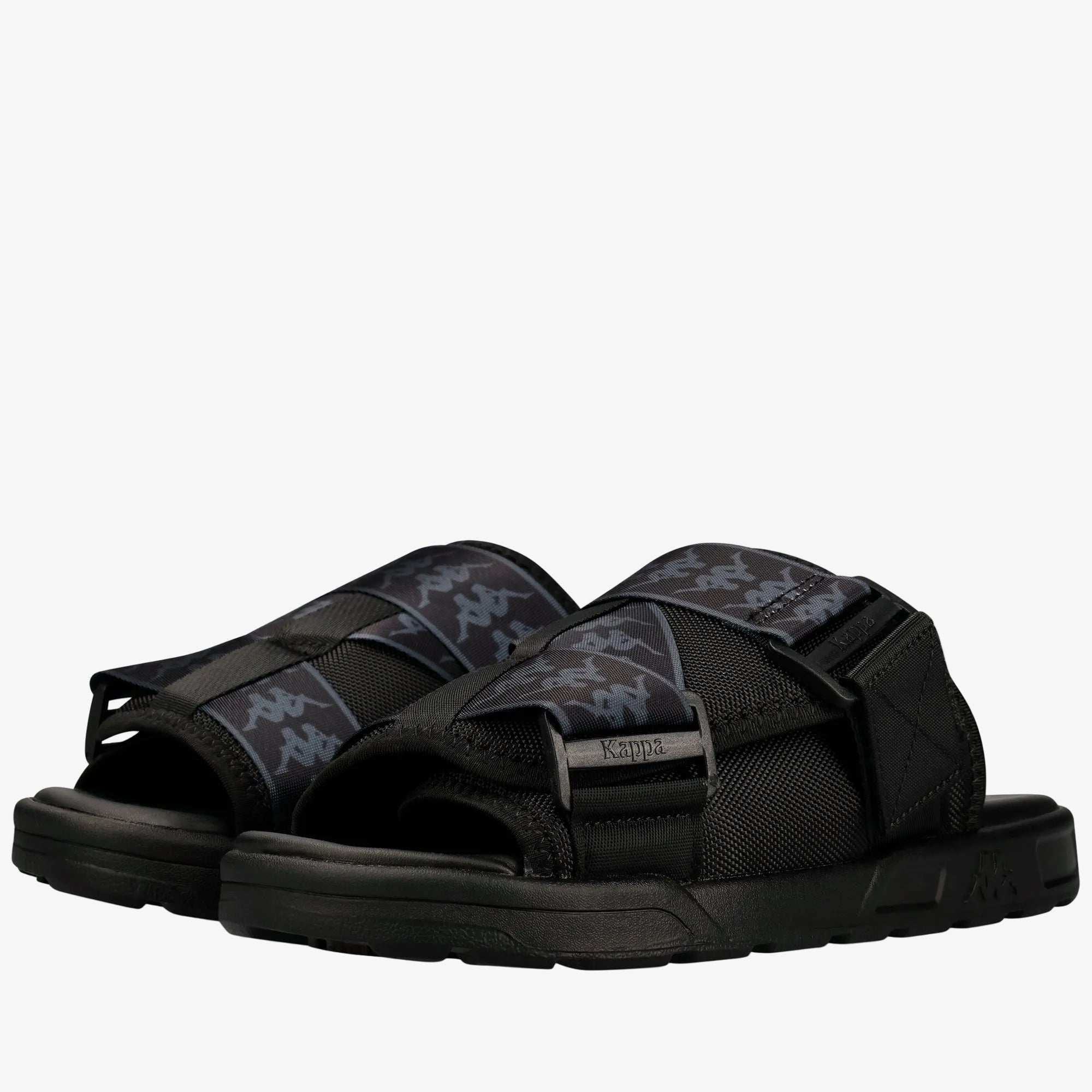 A pair of black Kappa slide sandals with gray and black logo-patterned straps, shown on a clean white background.
