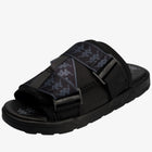 A black slide sandal with dark gray patterned straps and gray buckle details, shown from a three-quarters angle on a white background.