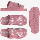 A pair of pink slides with white and grey geometric pattern on the strap and sole.