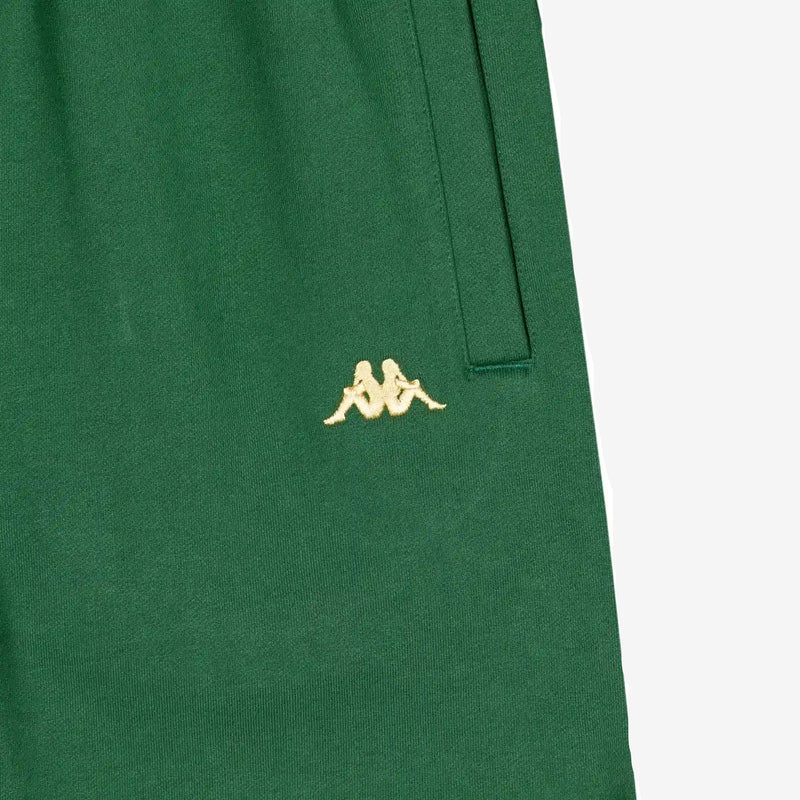 Detail view of golden yellow embroidered Kappa Omini logo on green shorts.