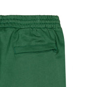 Detail view of back pocket of green shorts.