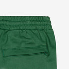 Detail view of back pocket of green shorts.