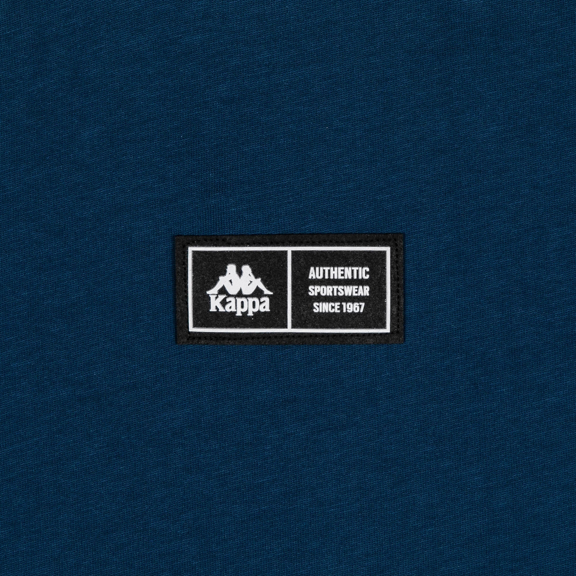 Detail view of silicone patch reading Kappa Authentic Sportswear since 1967.