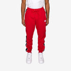 Red sweatpants with a brand logo worn by a person on a white background