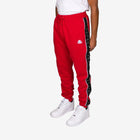 Red tracksuit with black side stripe worn by a person on a white background