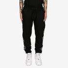 Black jogger pants with white stripes on a white background
