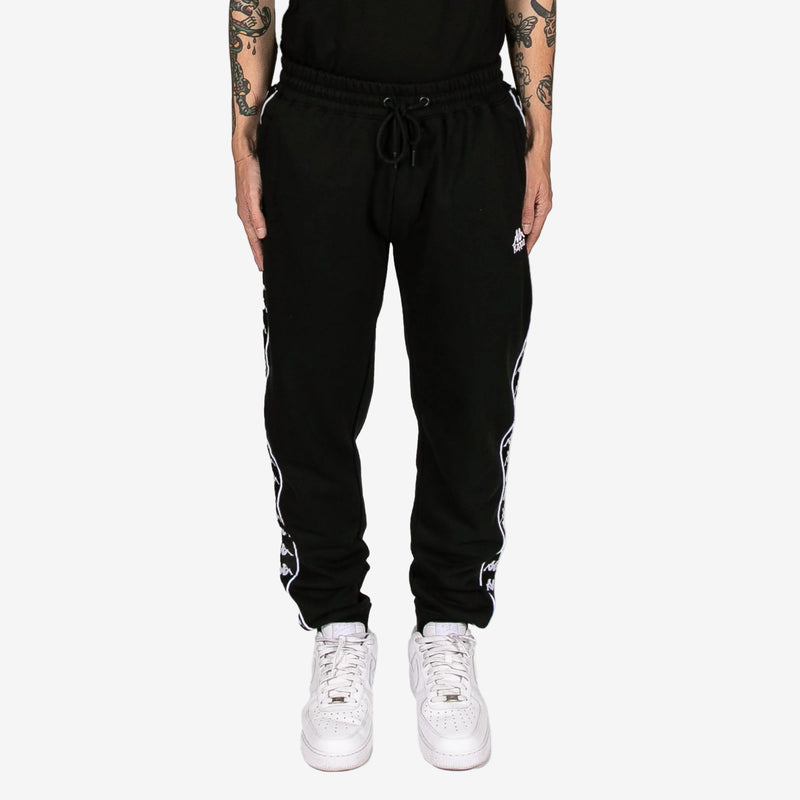Black jogger pants with white stripes on a white background