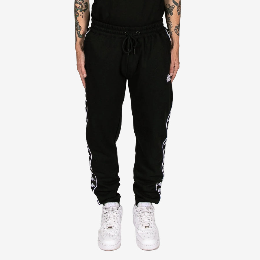 Black jogger pants with white stripes on a white background