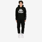 Person wearing a black Kappa tracksuit on a white background