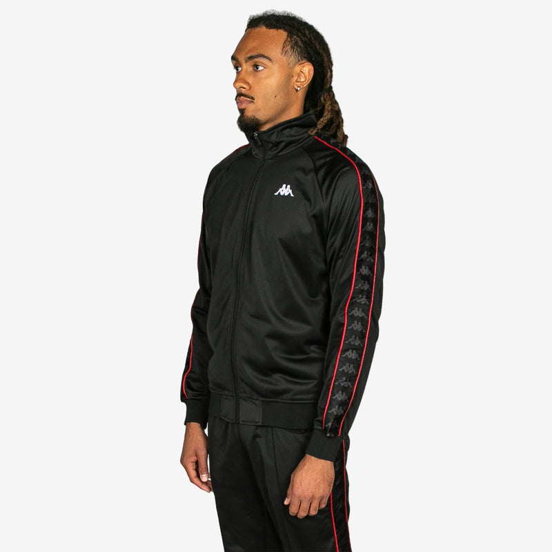 Person wearing a black tracksuit with red accents on a white background