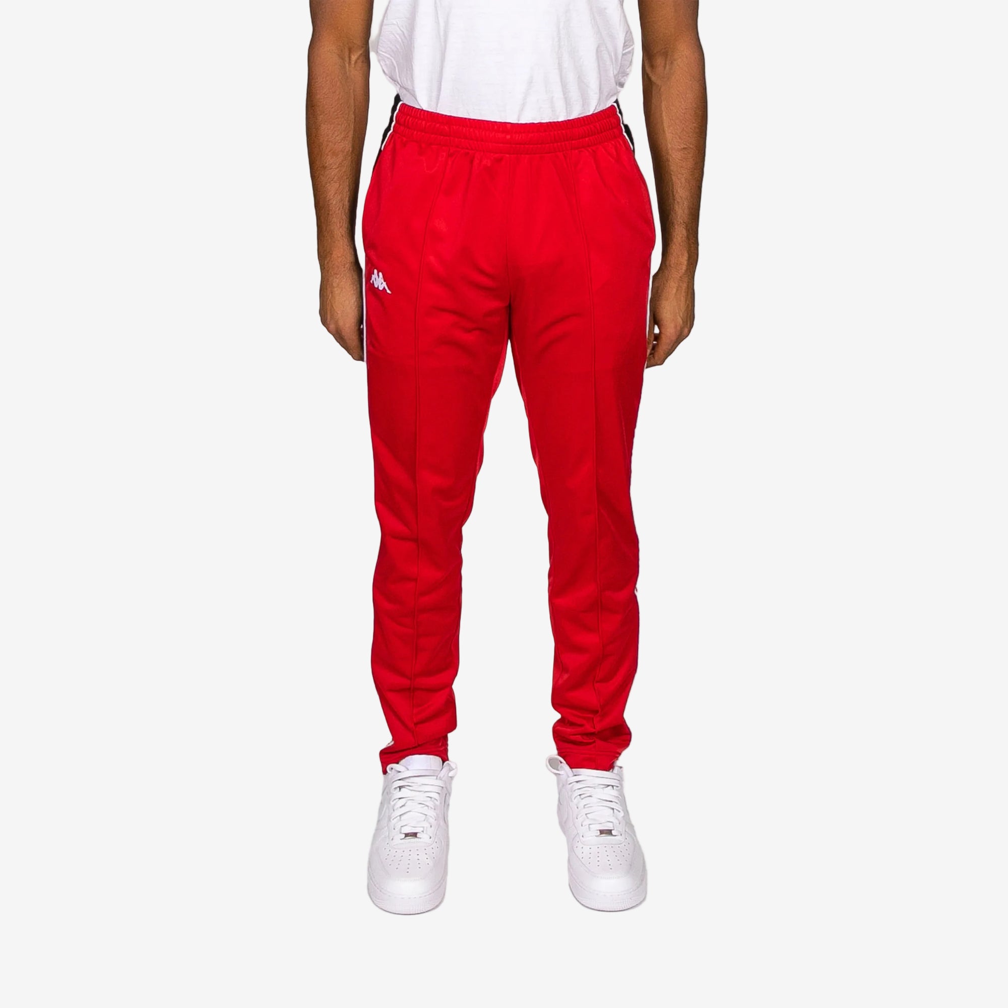 Red tracksuit pants worn by a person on a white background