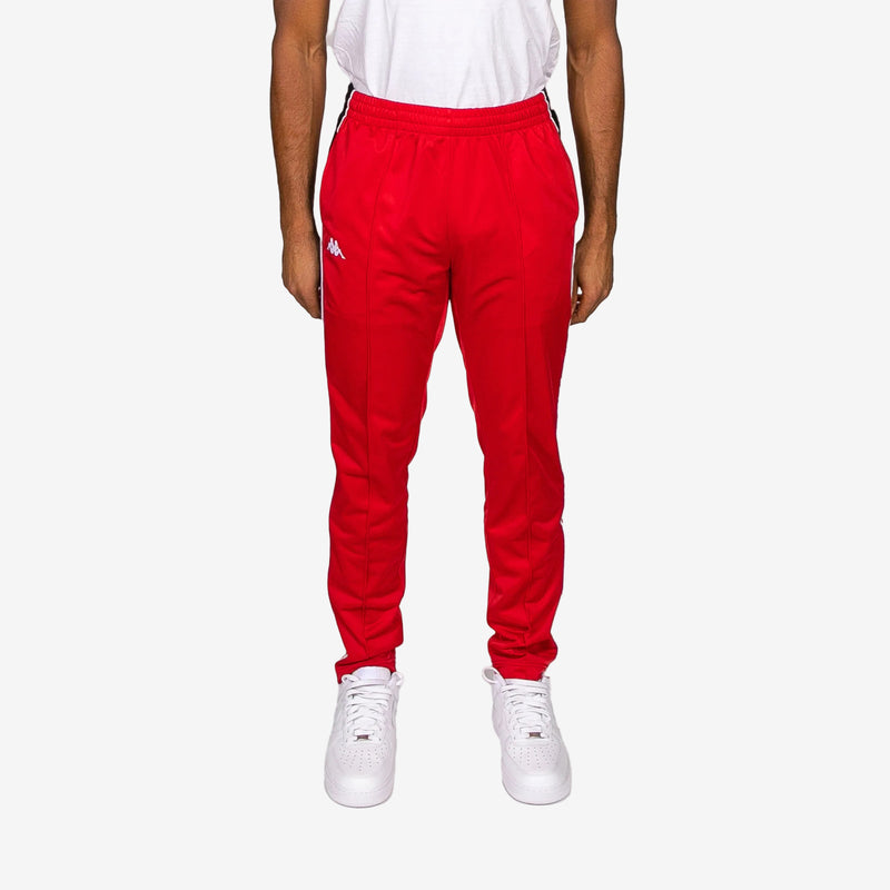 Red tracksuit pants worn by a person on a white background