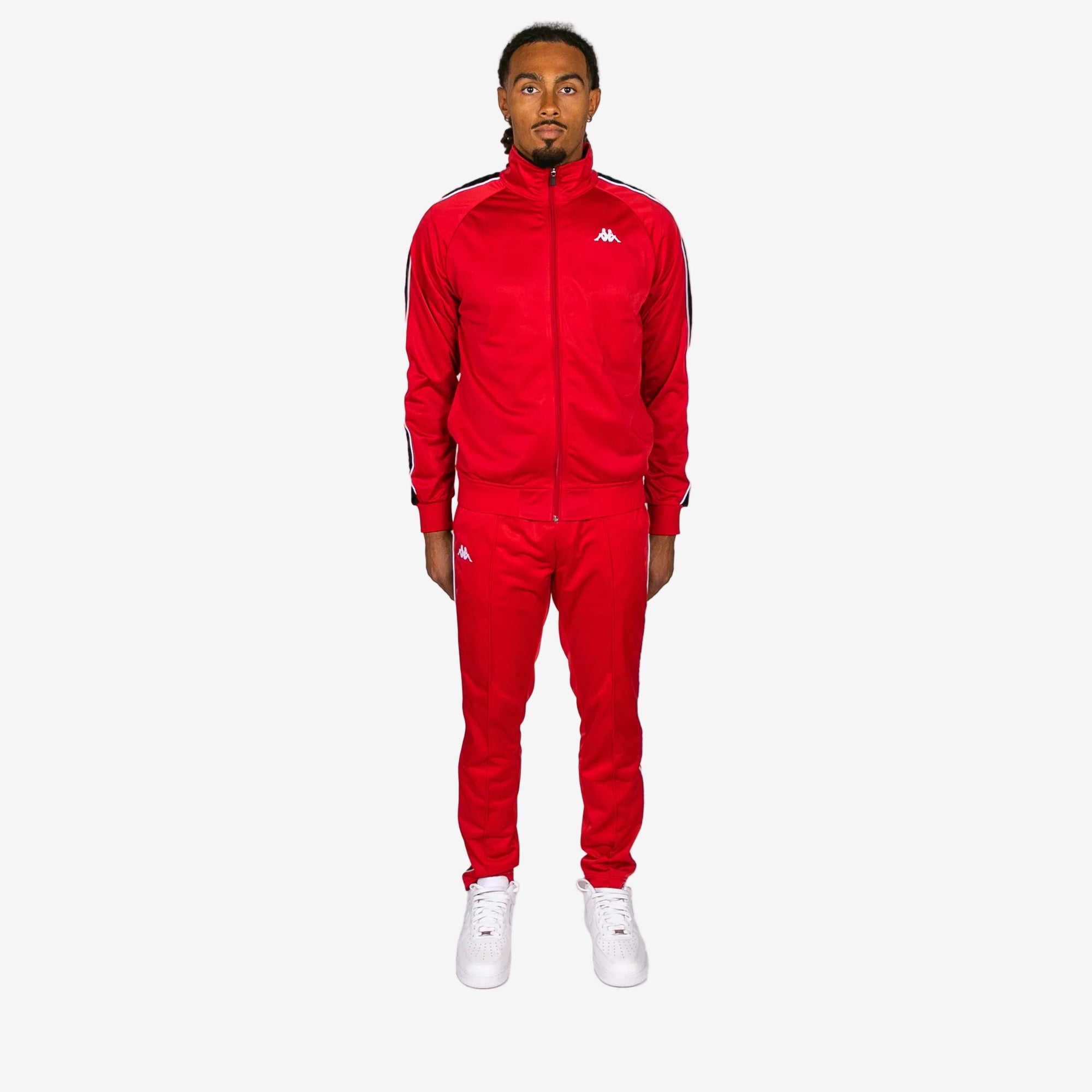 Person wearing a red tracksuit with white accents on a white background