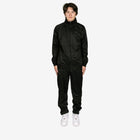 Person wearing a black tracksuit on a white background