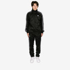 Person wearing a black tracksuit with white stripes on a white background