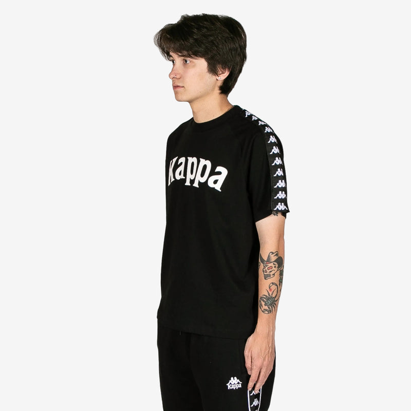Person wearing a black Kappa t-shirt with white text and graphics on a white background