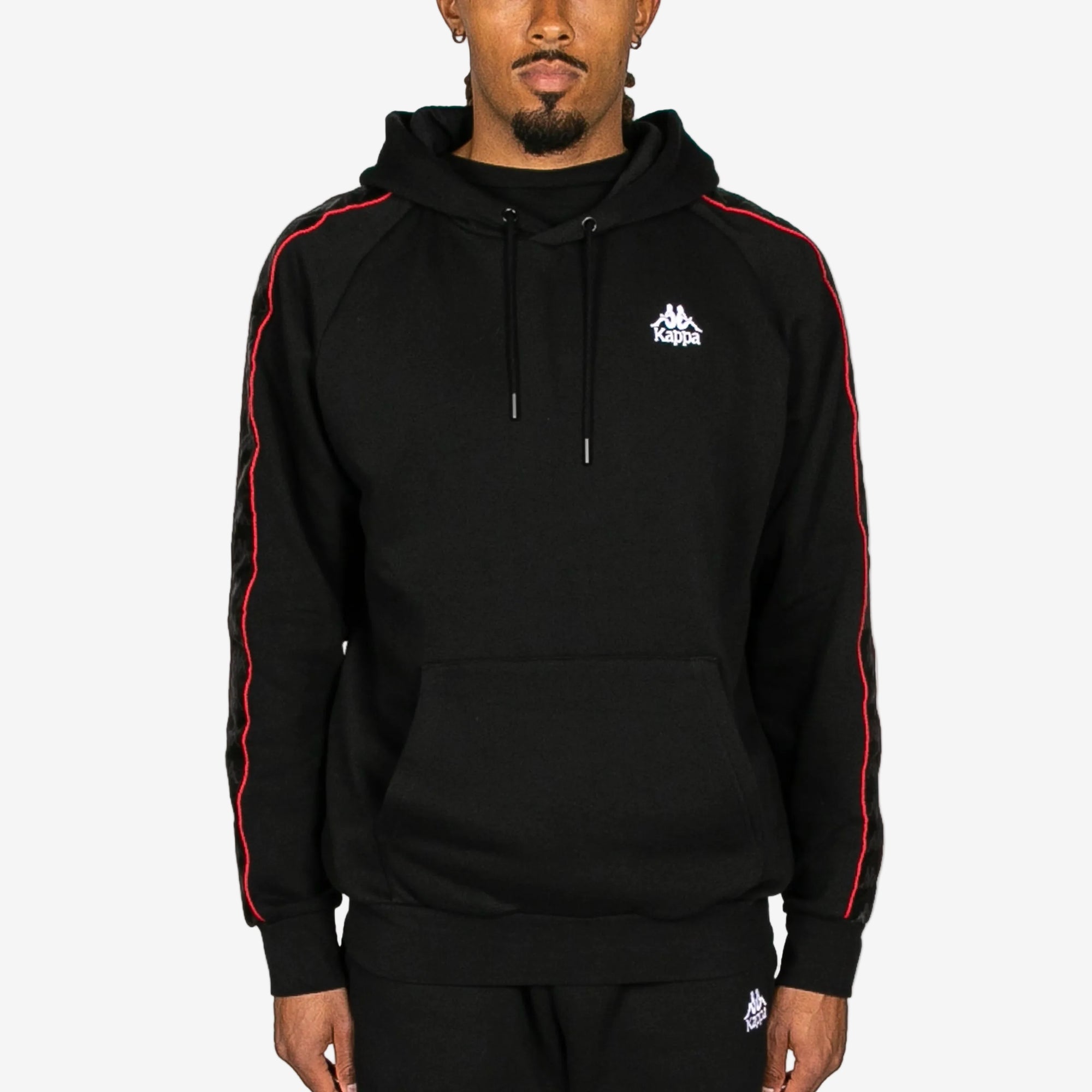 Black hoodie with red stripes and Kappa logo worn by a person on a white background