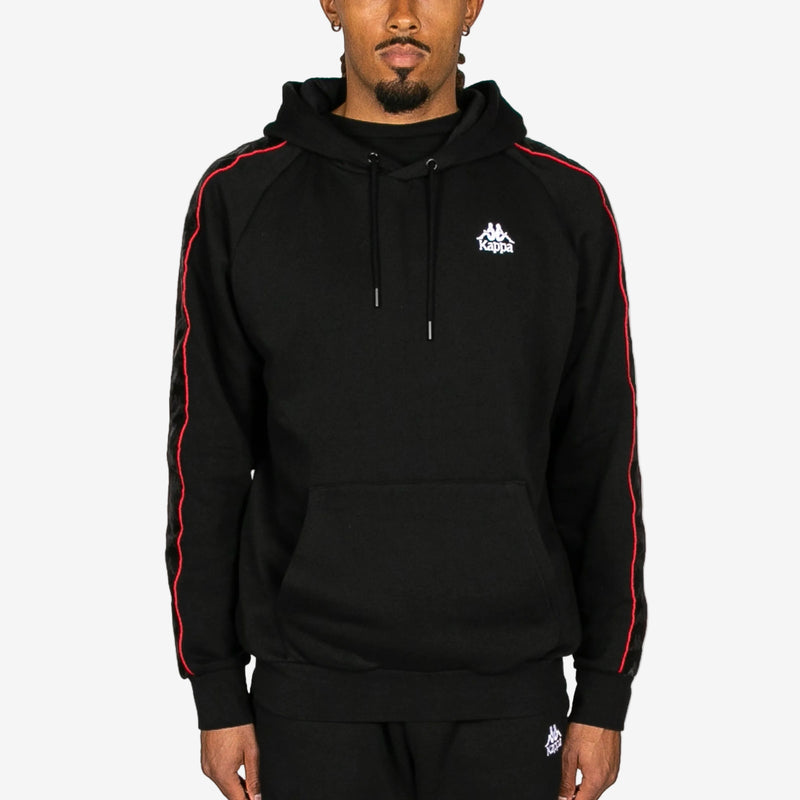 Black hoodie with red stripes and Kappa logo worn by a person on a white background