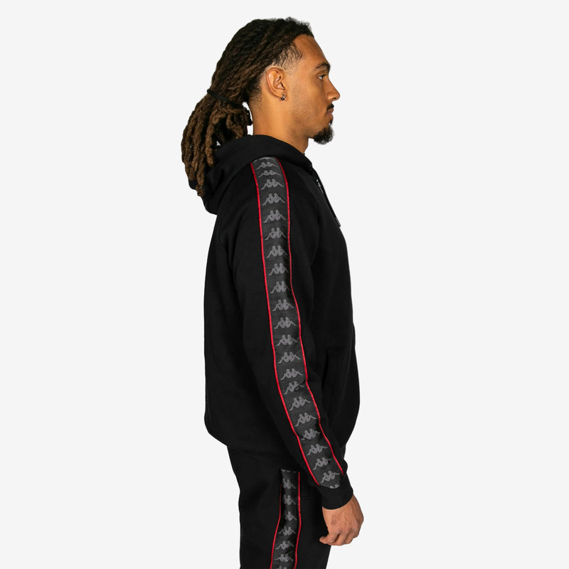 Person wearing a black hoodie with a patterned sleeve on a white background