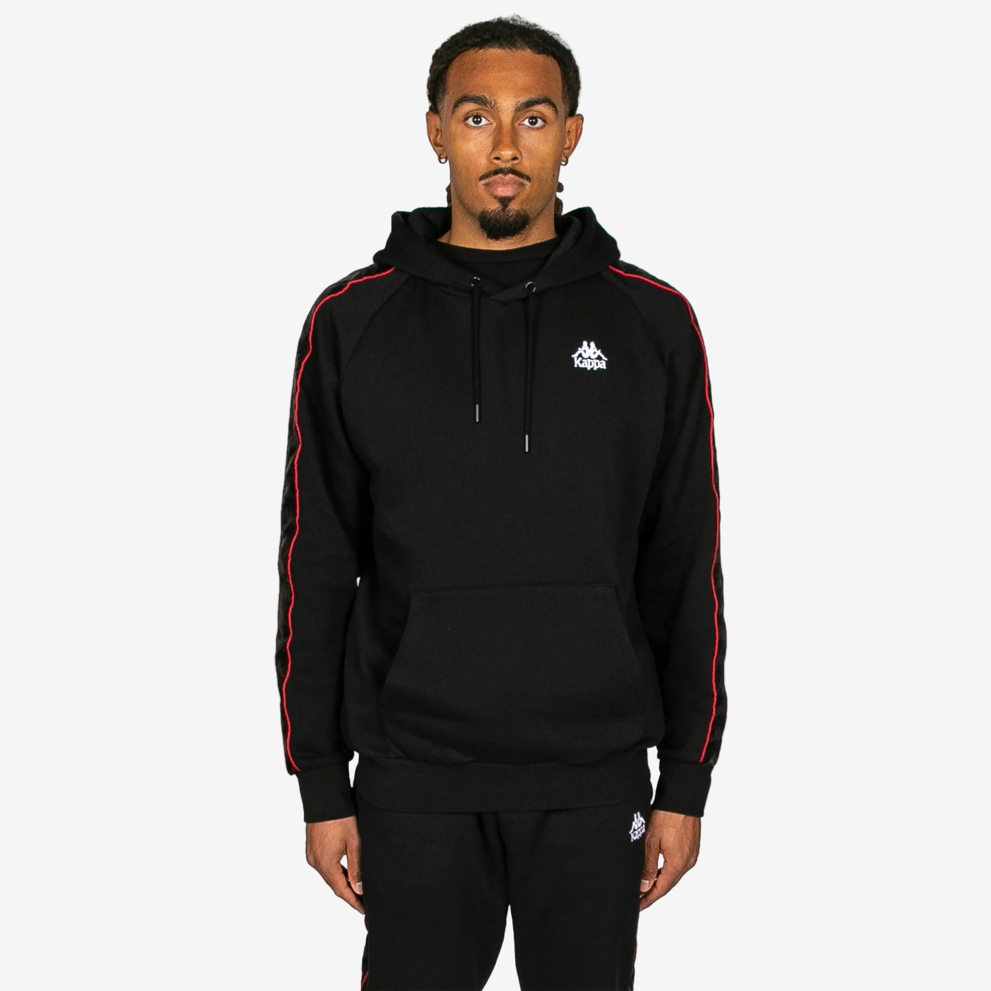 Person wearing a black hoodie with red stripes on a white background