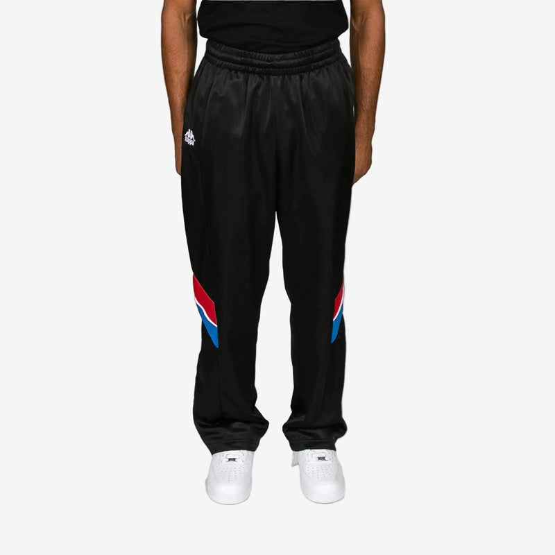 Black pants with colorful accents worn by a person on a white background