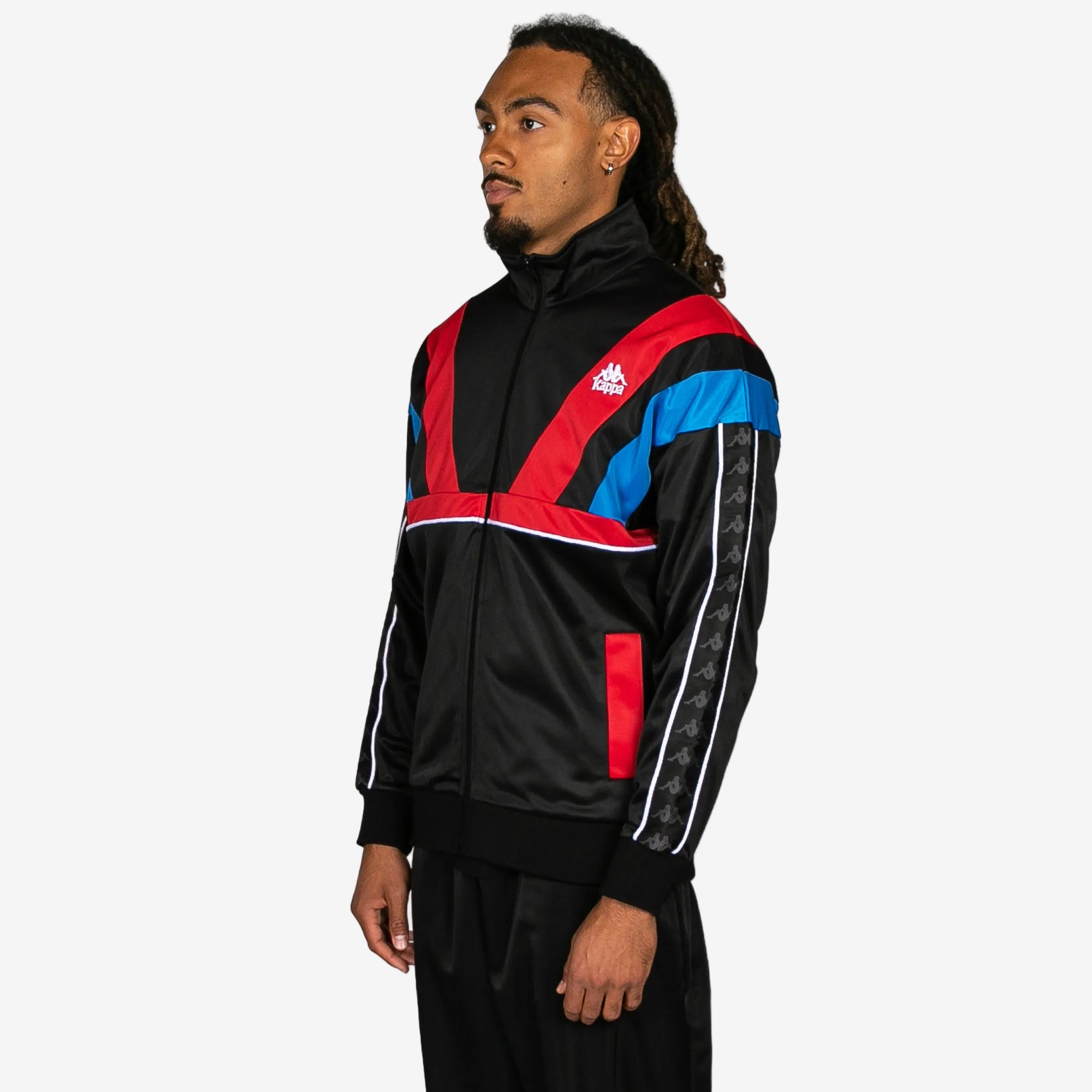 Person wearing a black, red, and blue tracksuit with a brand logo on a white background