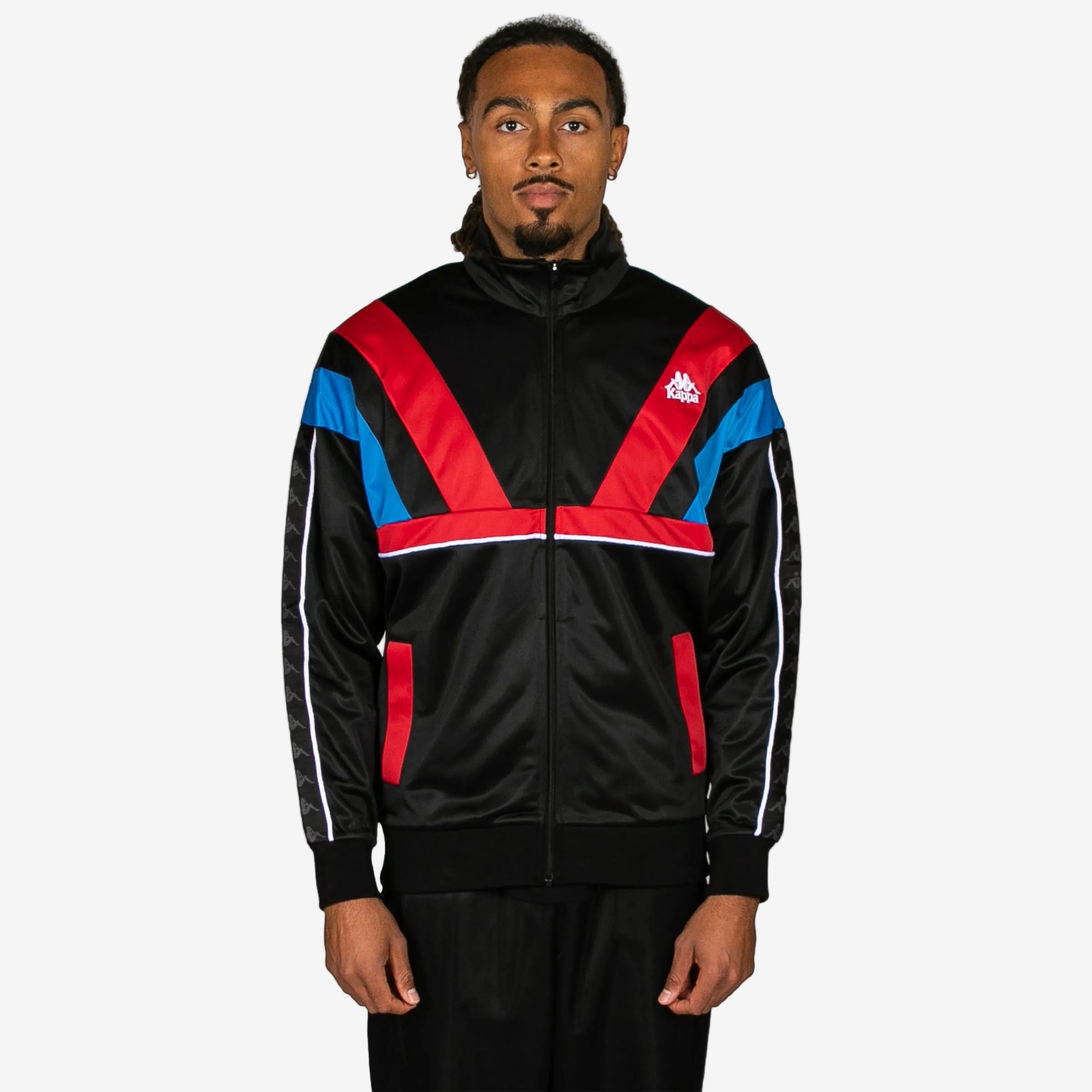 Man wearing a black tracksuit with red and blue accents on a white background
