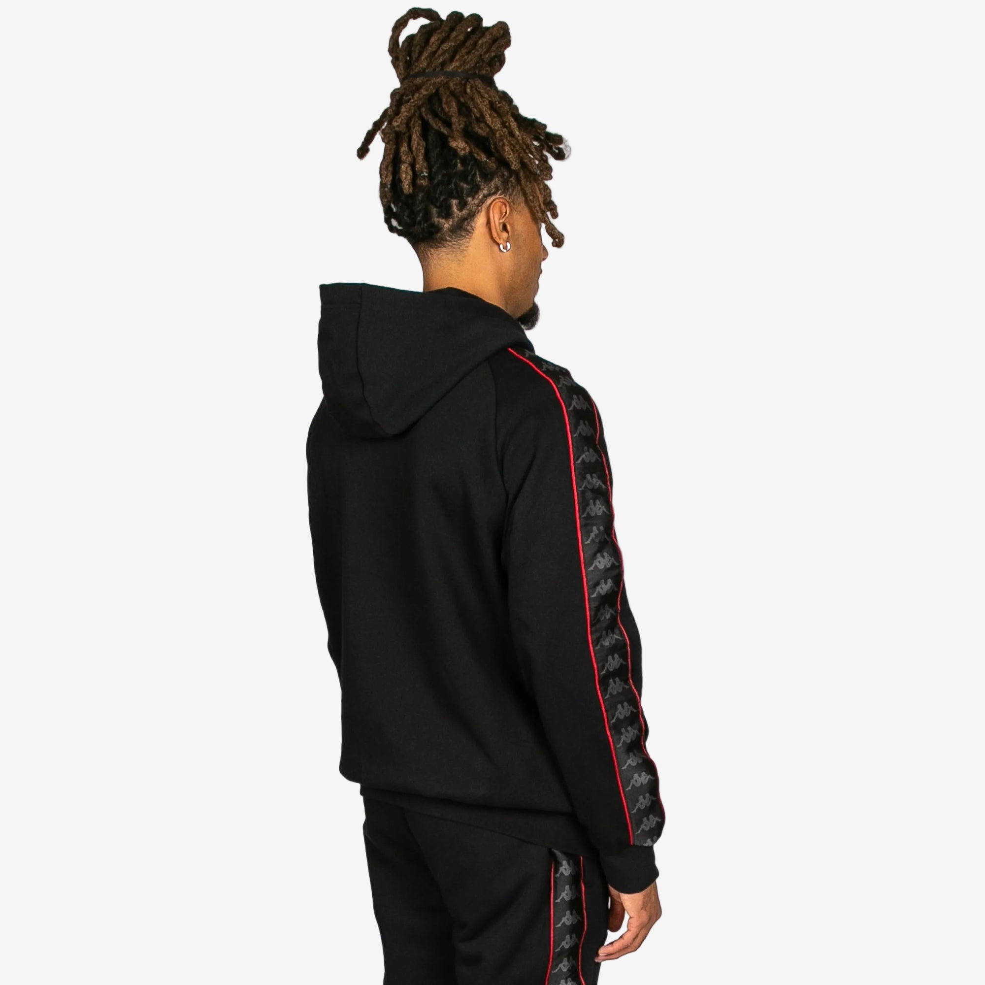 Person wearing a black hoodie with red and gray pattern on a white background