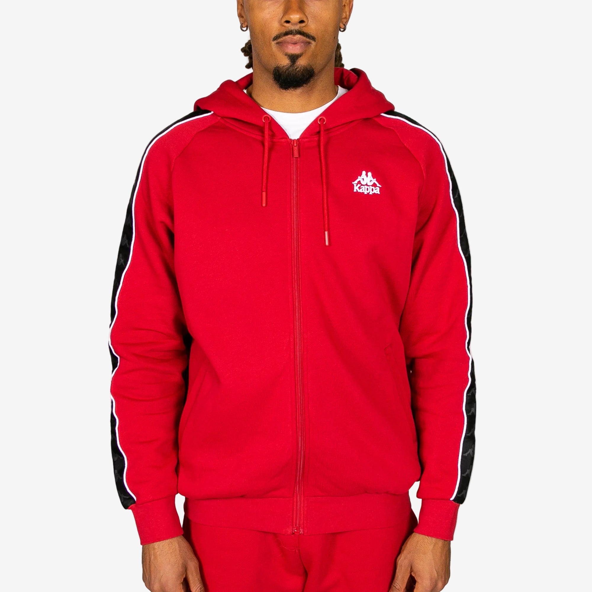 Red hoodie with black stripes on sleeves and Kappa logo, worn by a person on a white background