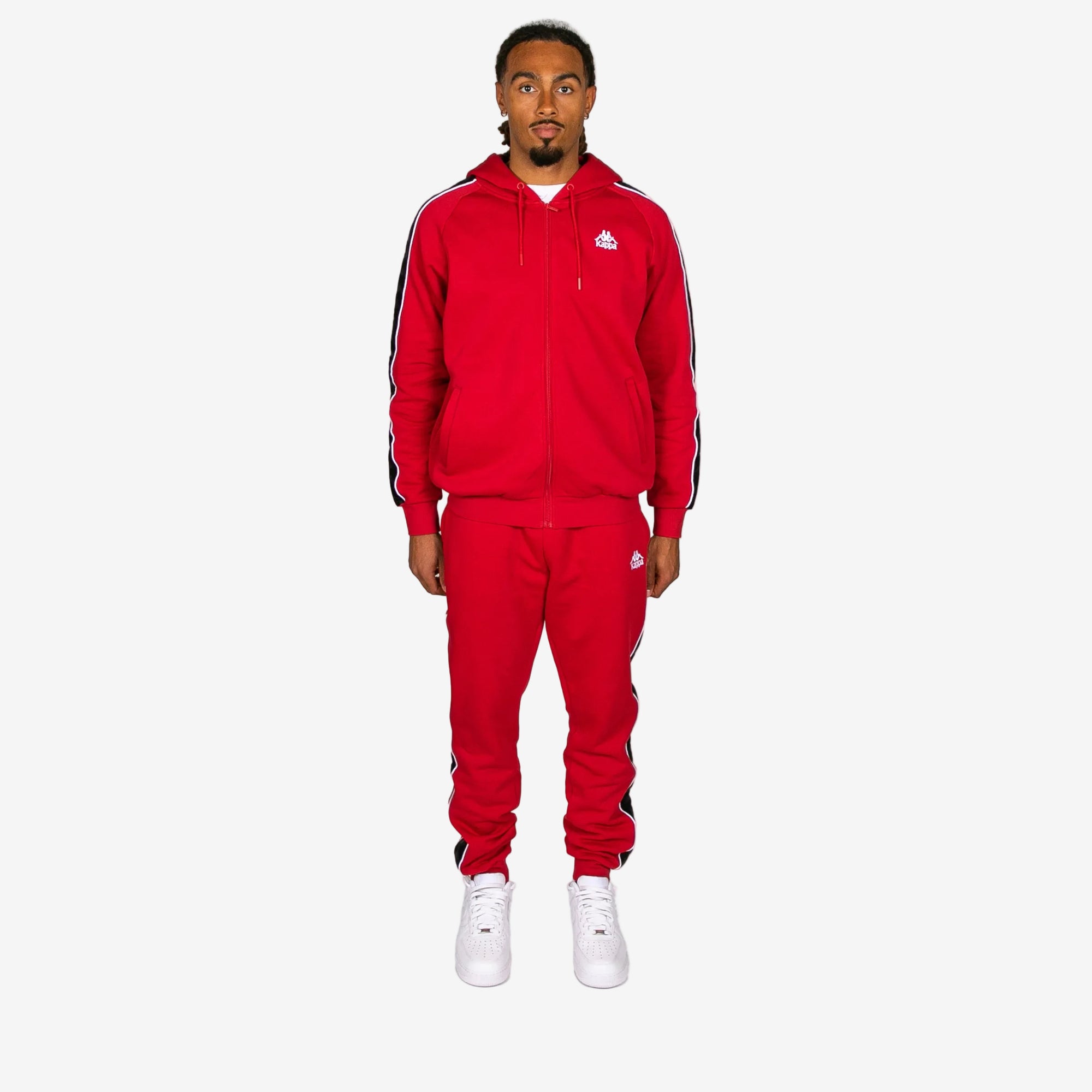 Person wearing a red Adidas tracksuit on a white background