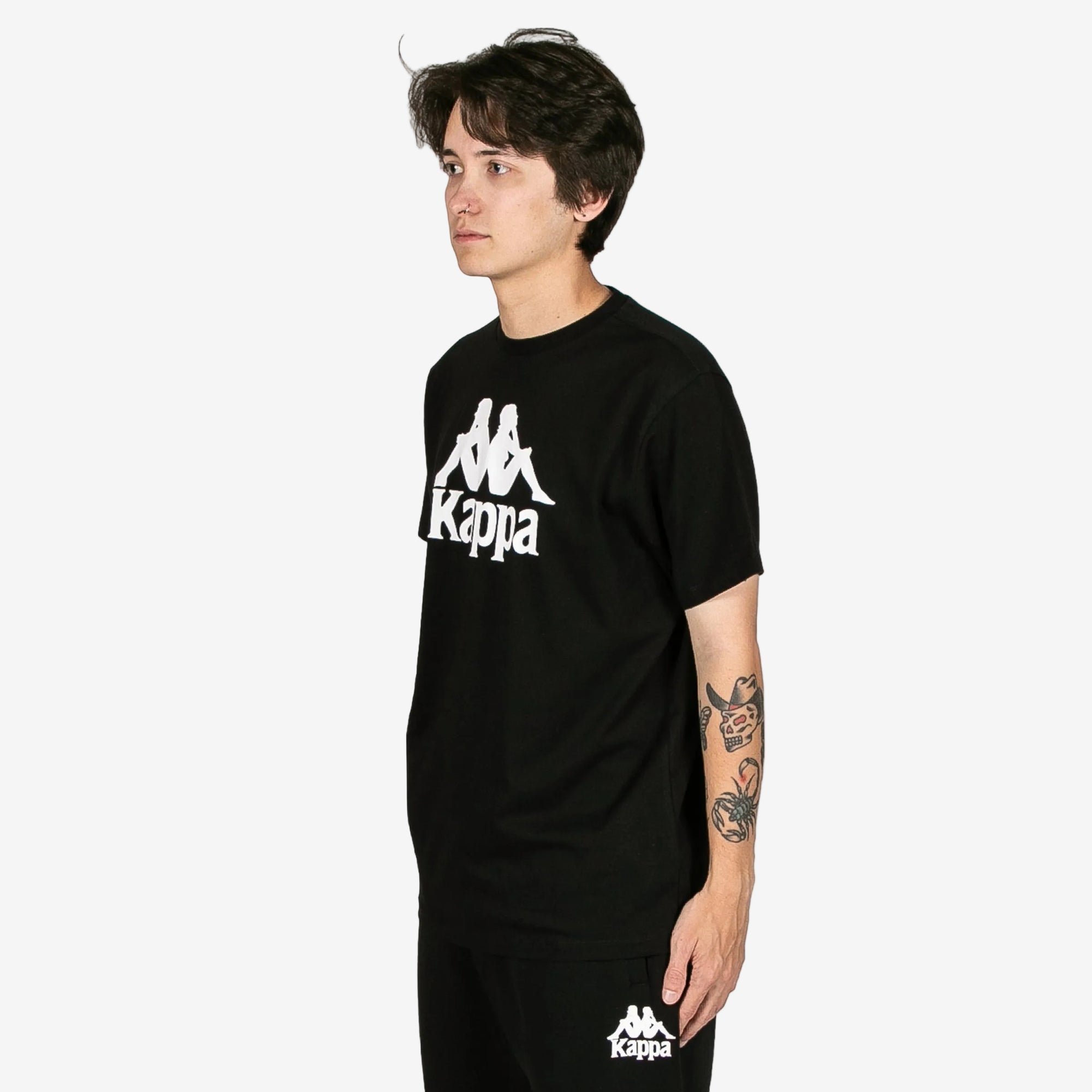 Person wearing a black Kappa t-shirt on a white background