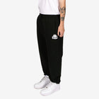 Person wearing black Kappa sweatpants on a white background