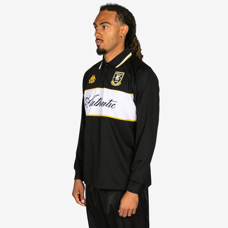 Man wearing a black and white sports jersey with visible branding on a white background