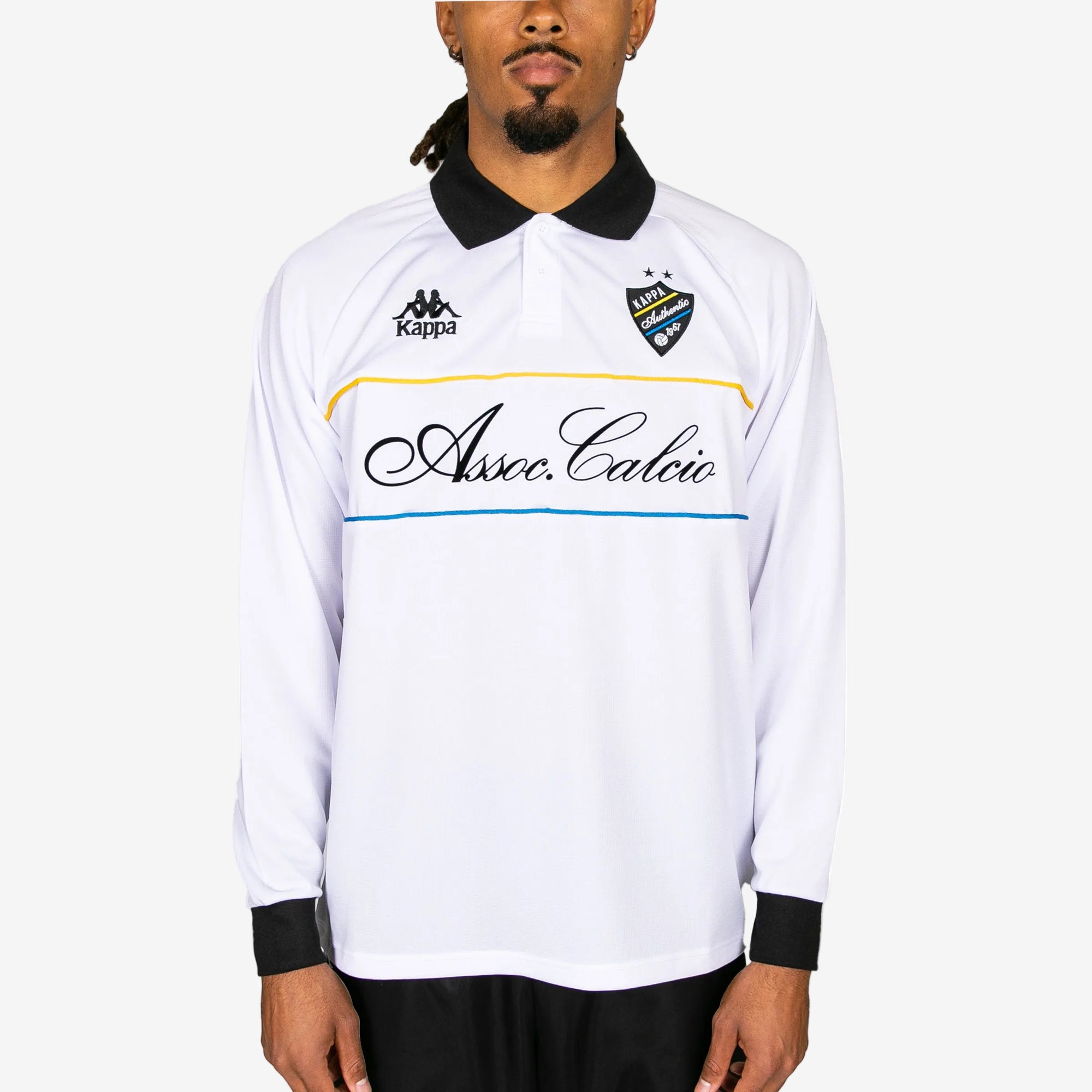 Person wearing a white long-sleeve shirt with black collar and sleeves, featuring Kappa branding and 'Asseccalce' text.