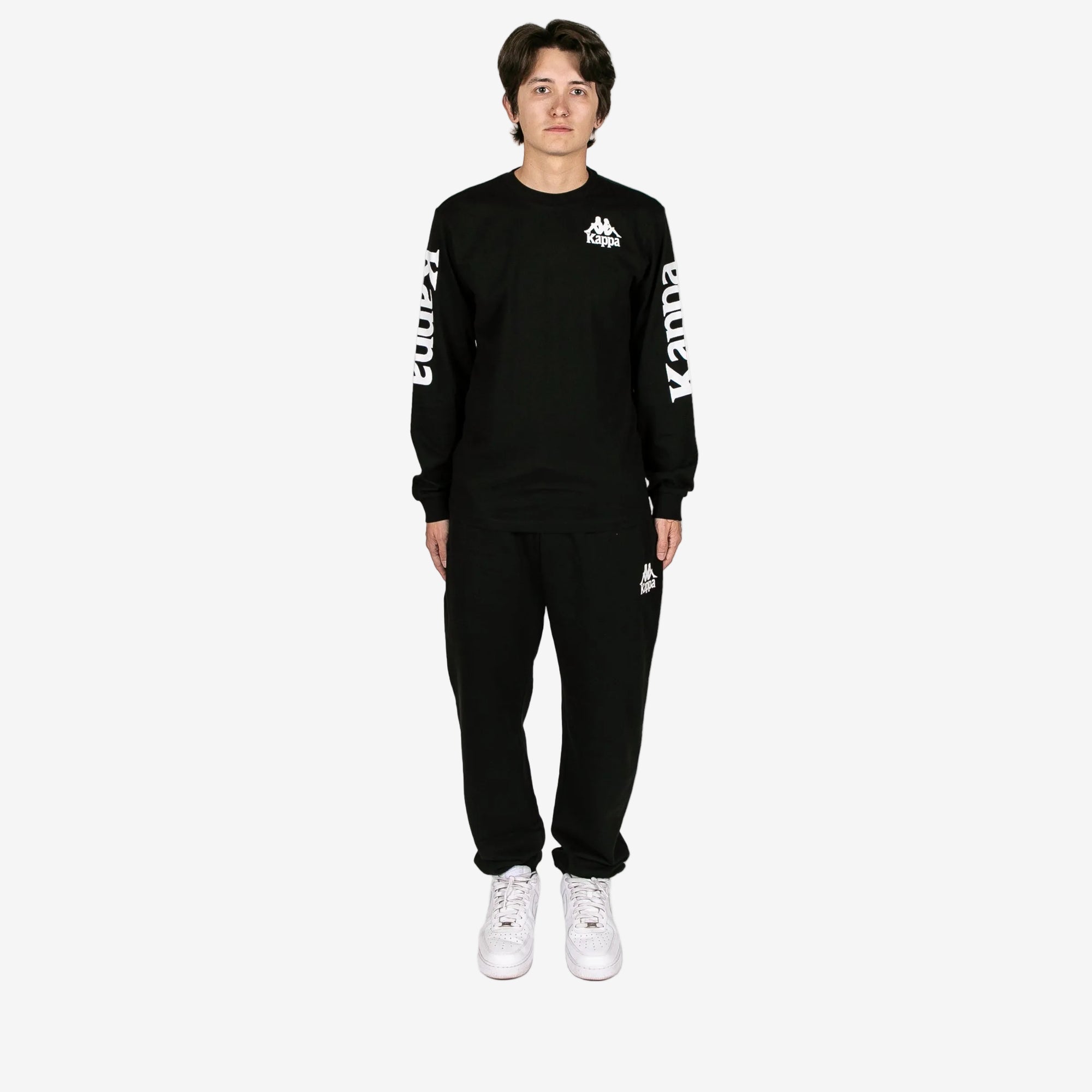 Person wearing a black tracksuit with white text on a white background
