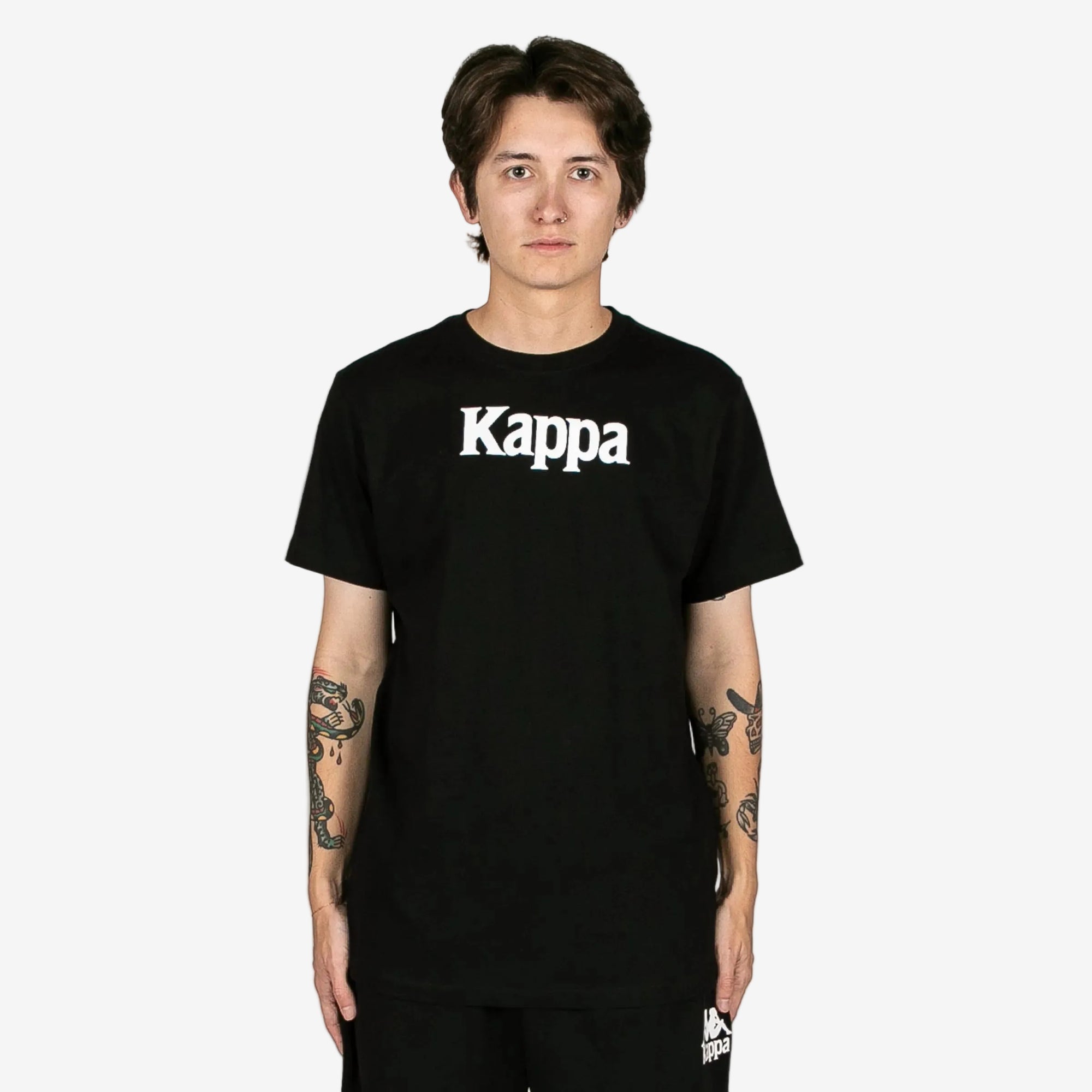 Person wearing a black Kappa t-shirt on a white background