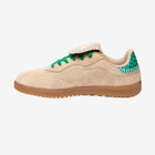 Beige sneaker with green accents on a white background