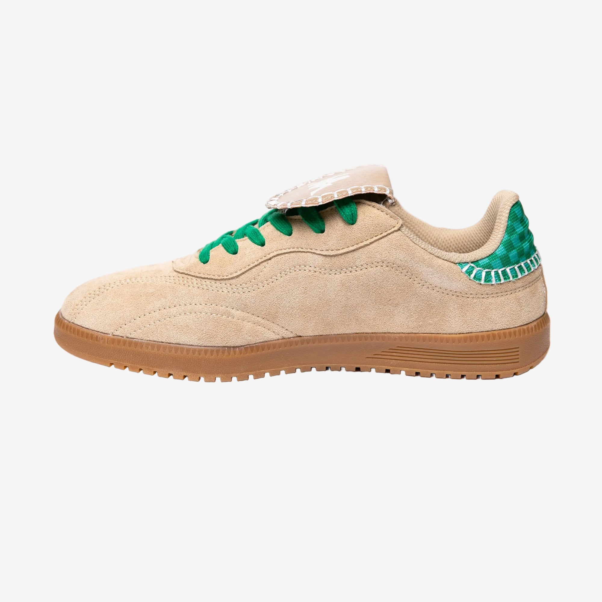 Beige sneaker with green accents on a white background