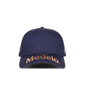 Navy blue cap with Modelo logo in gold across front bill.